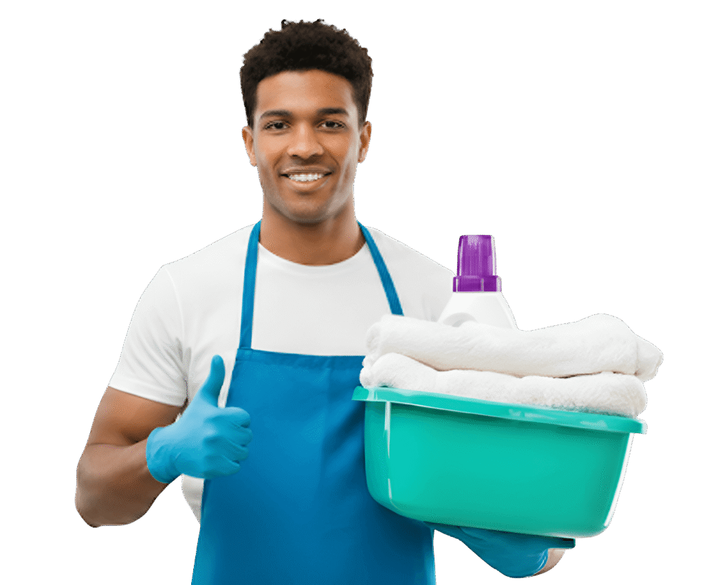A smiling professional cleaner wearing gloves and an apron holding a laundry basket filled with folded towels and detergent, giving a thumbs-up gesture.