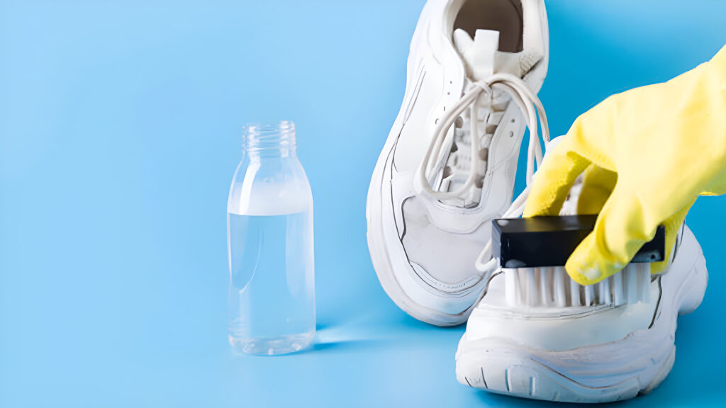 Cleaning white sneakers with a brush.