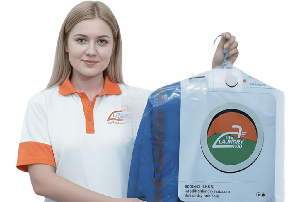 lady worker at laundry hub showing clean cloths neatly ironed and packed under plastic cover on a hanger