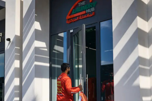 Customer entering The Laundry Hub storefront entrance