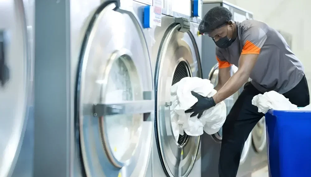 man taking out fresh laundry from machine